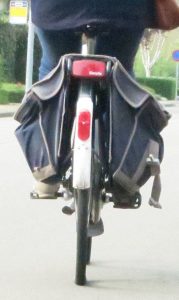 Review of a bicycle with saddle bags riding down the road.