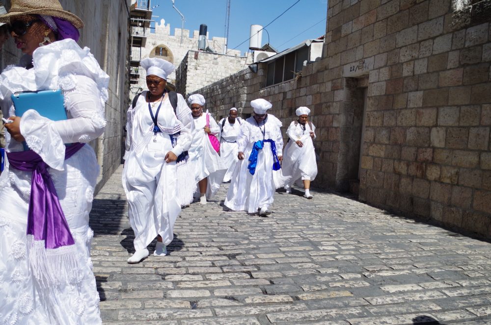A group of people in all-white outfits, walking in socks.