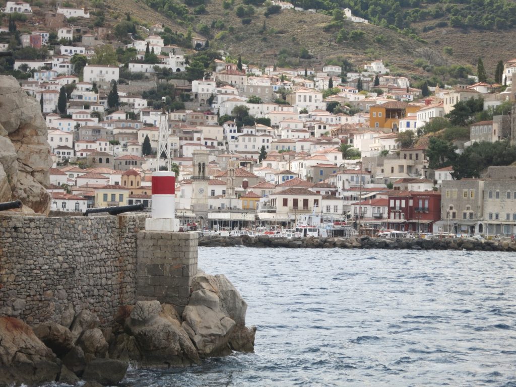 White houses clustered up the side of a hill from the waterfront.
