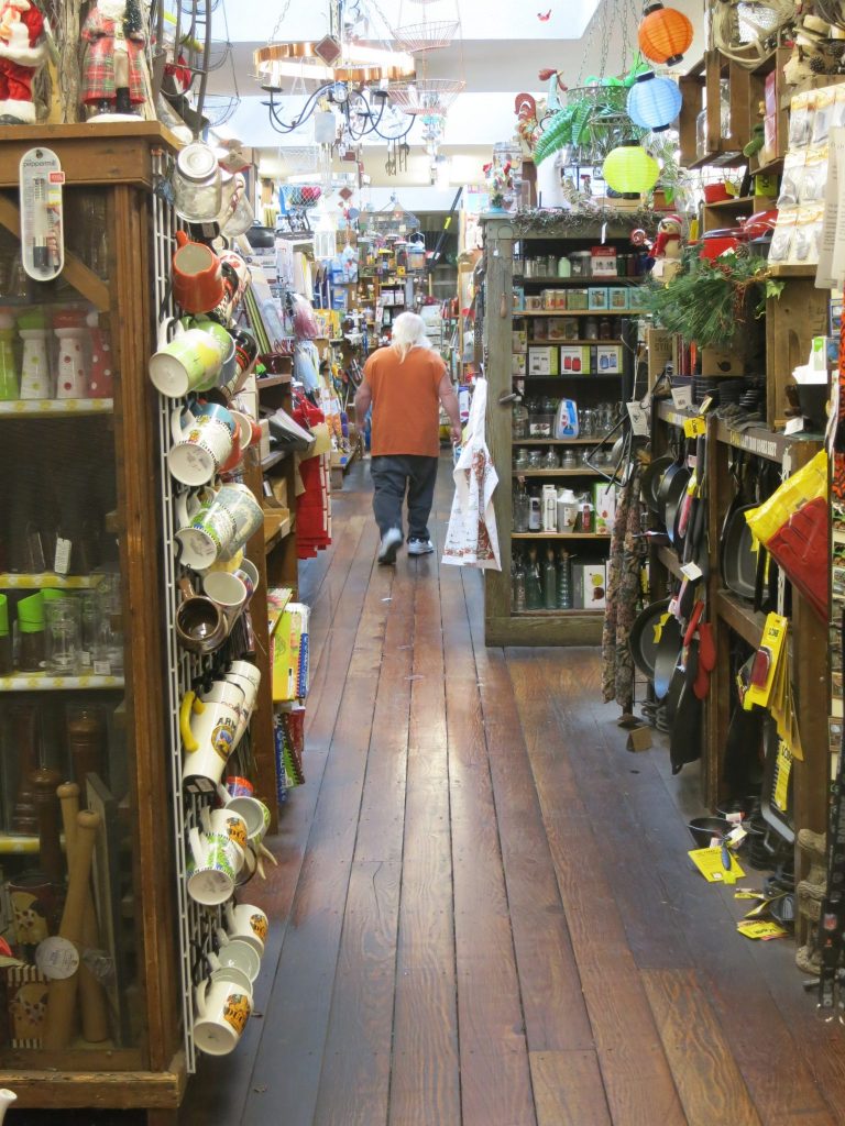 this view looks down one aisle of the story. Visible items from floor to ceiling: ranging from kitchen utensils to a Santa Claus figure. 