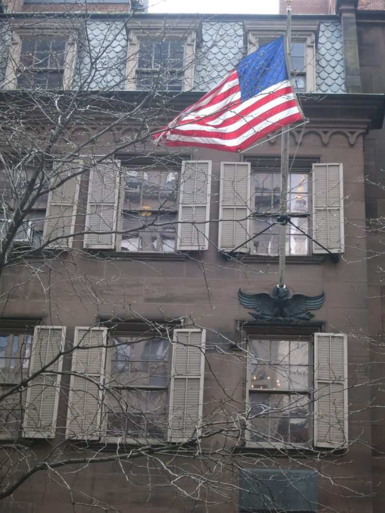 the Theodore Roosevelt Birthplace Museum exterior: a brownstone with an American flag fluttering in the breeze