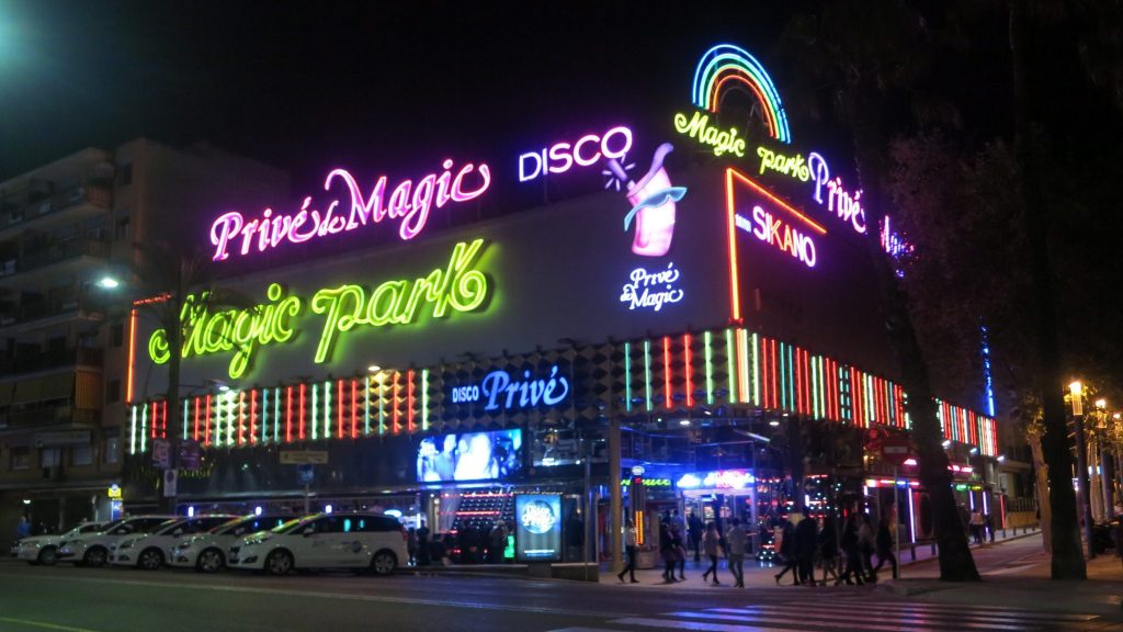 building in Lloret de Mar with neon-lighted signs reading Prive de Magic Disco, Magic Park, etc.