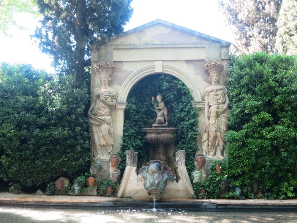 While the main structure of the fountain includes two classically-posed female statues in the garden of the Gala Dali museum, the fountain below is flanked by a number of small, identical carvings of heads: Wagner's face, repeated.