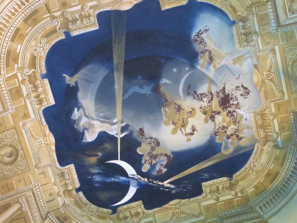 The ceiling of the throne room in the Gala Dali castle references rococo style, but with a surrealistic twist.