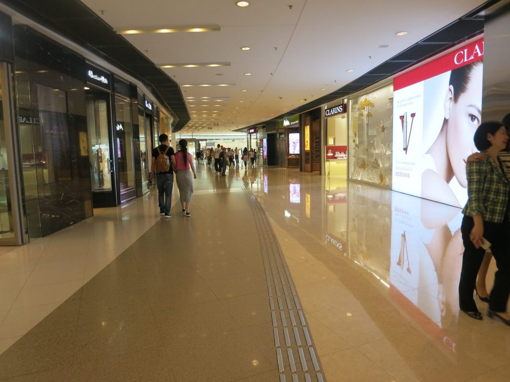 view of a shiny, clean and relatively empty hallway in an upscale shopping mall in Hong Kong