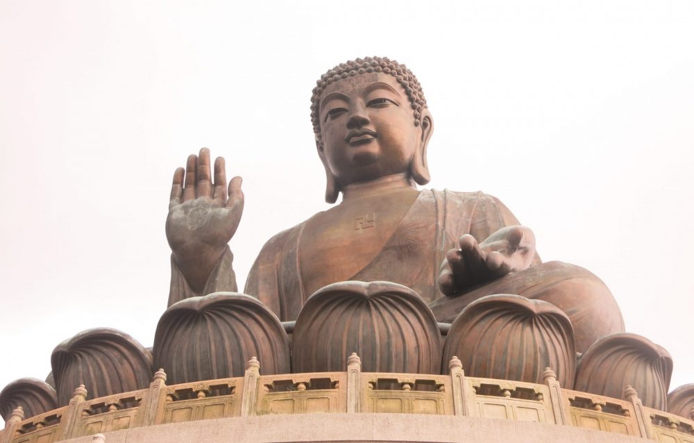 The Big Buddha sits in a lotus, his right hand raised