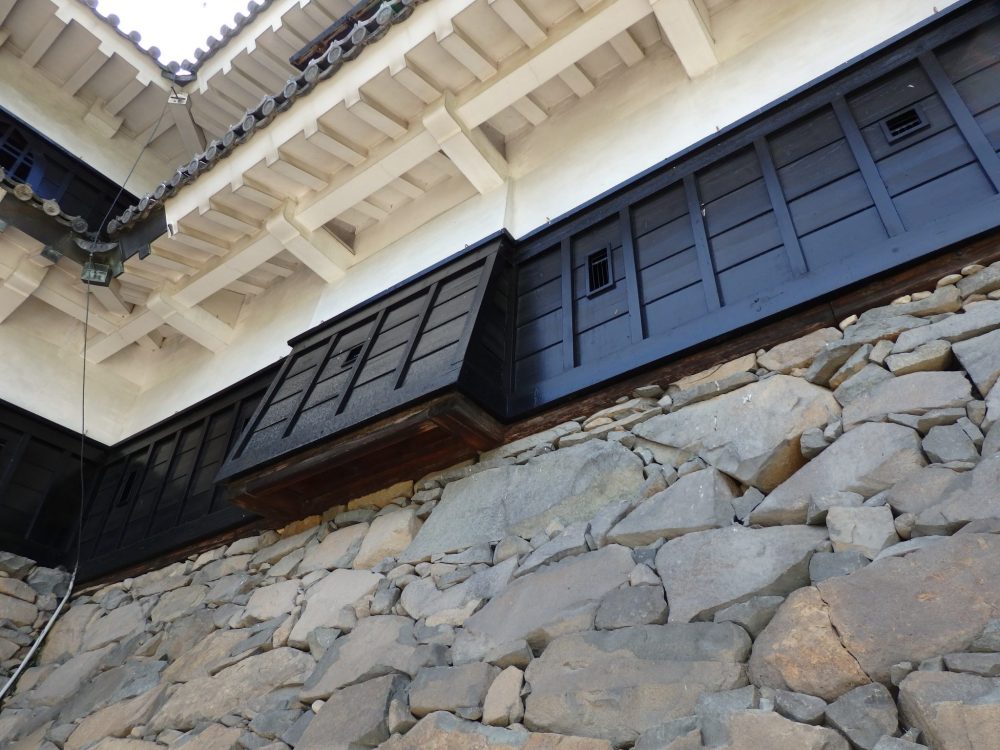 A piece of the wall extends out, allowing soldiers inside to drop stones on invading forces, at Matsumoto Castle.