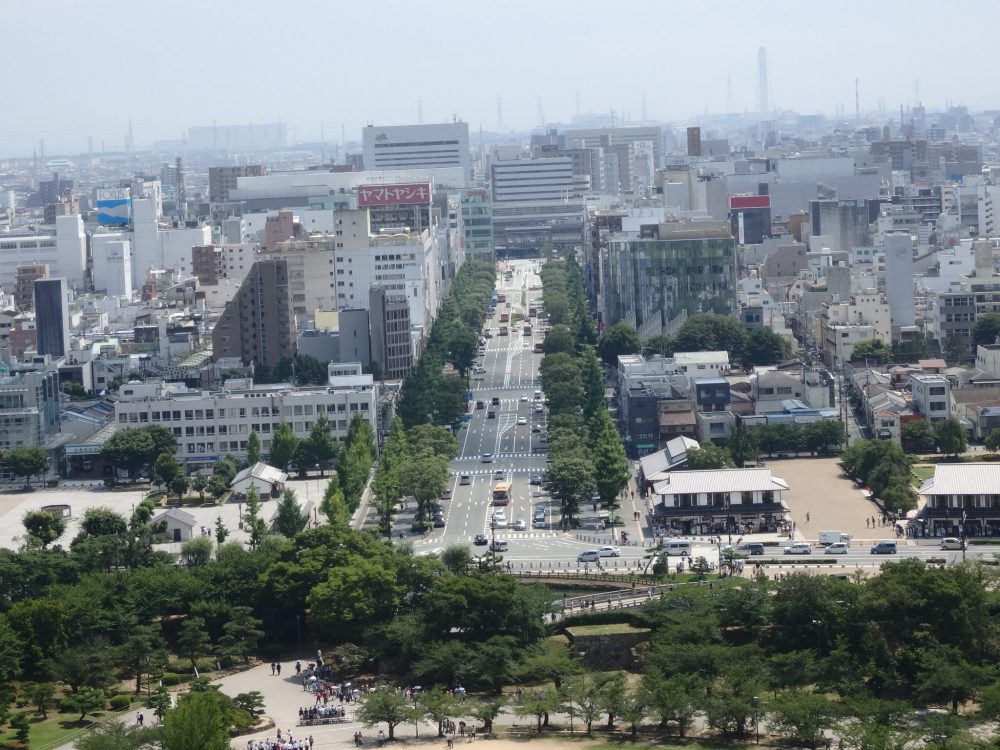 Things to do in Himeji: looking down the same boulevard from Himeji Castle toward the train station: the boulevard is wide and the buildings are typical uninteresting city buildings.