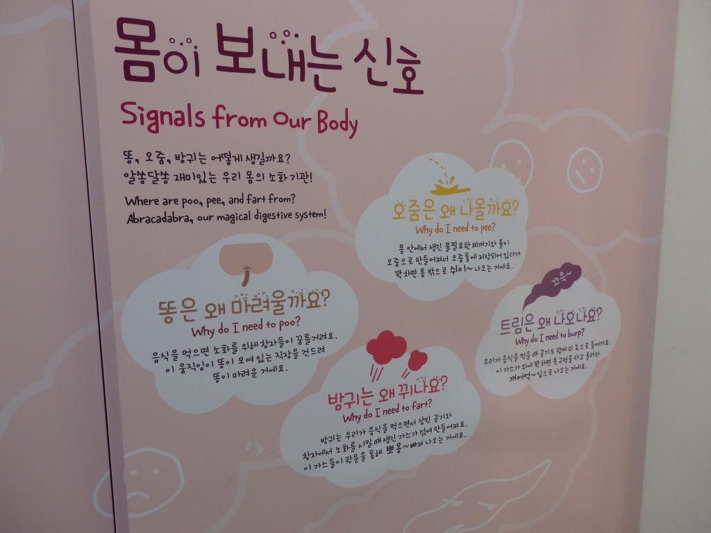 The sign asks questions like "Why do I need to poo?" and "Why do I need to fart?" but the answers under each are only in Korean.