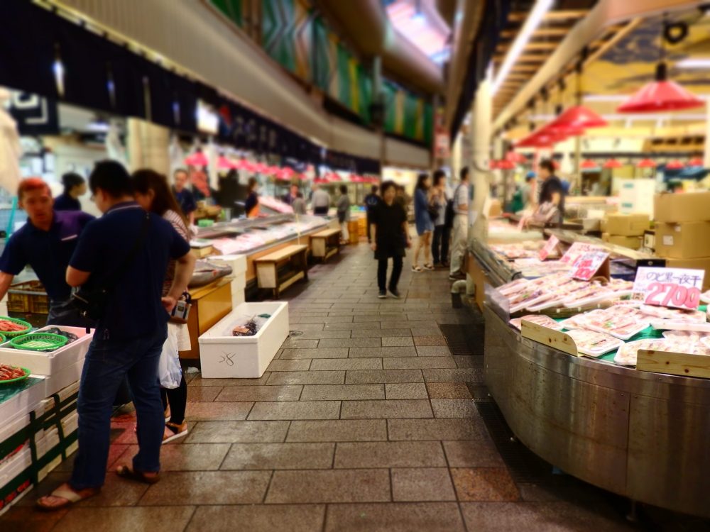 The seafood section of the market in Kanazawa. Looking down an aisle with stands on either side and a few customers shopping. Is Kanazawa worth a visit?