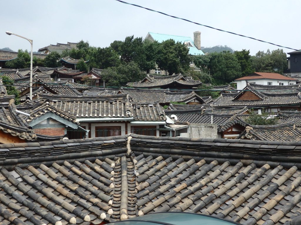 view over part of Buckchon Hanok Village - all of the roofs are the traditional tiling with curved eaves.