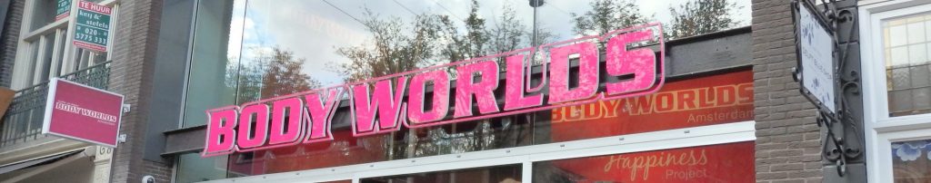 The sign that says "Body Worlds" in big pink letters.