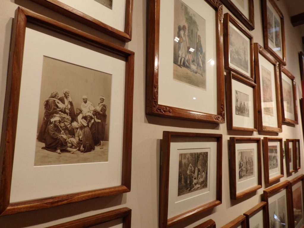 A section of one of the picture walls, this one showing antique photos and lithographs involving cannabis use