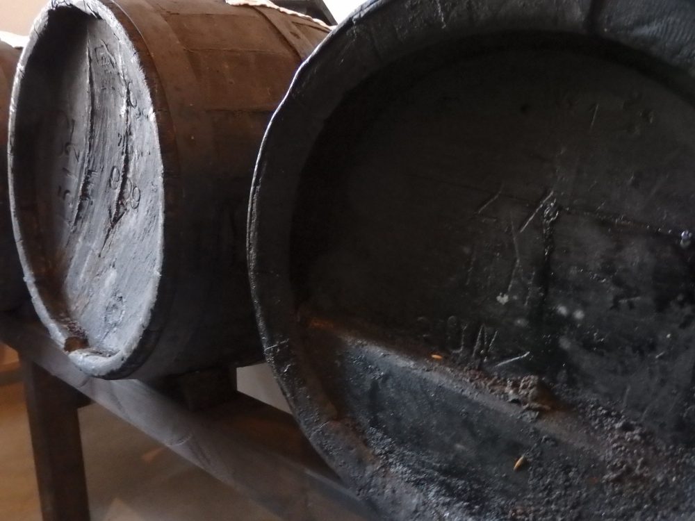 Close-up of two ends of barrels. looking very dark and weathered and dirty. Seen on the Italian Days Food Tour