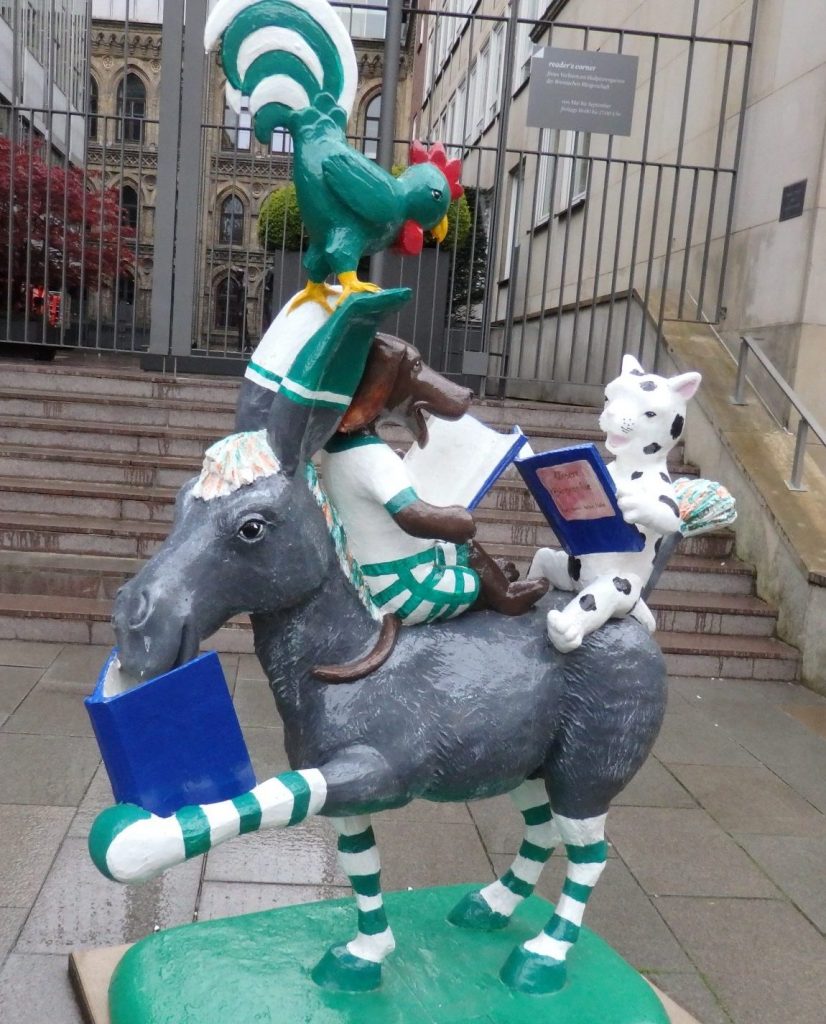 an image of the town musicians of Bremen, in this case, reading books