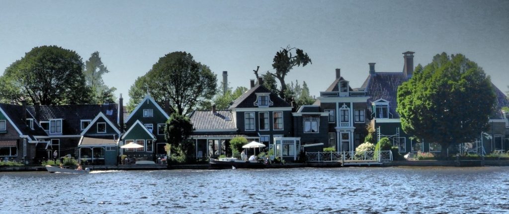 The row of houses sit right on the edge of the water: wooden houses, just 2-3 stories high, with peaked roofs.