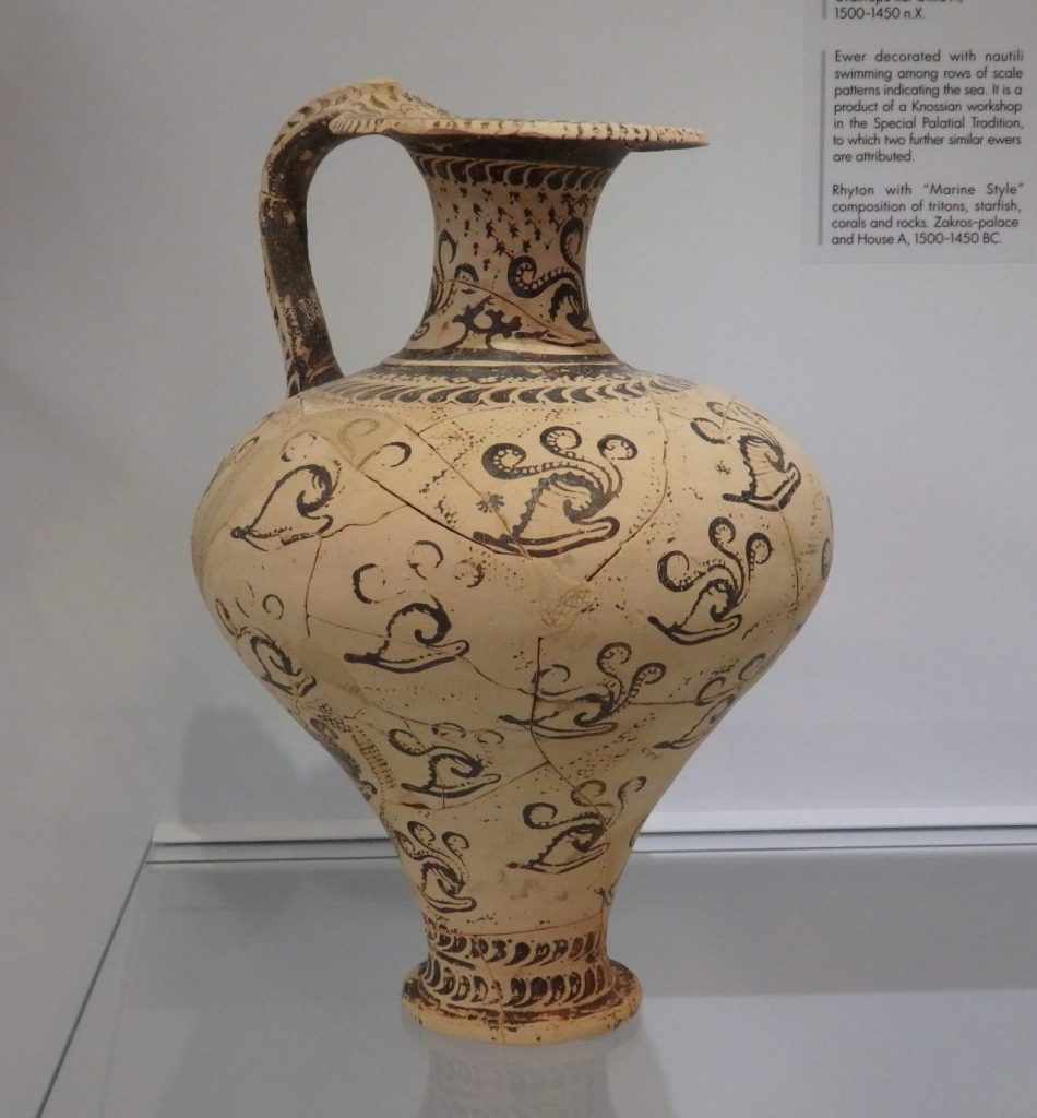 An elegant pitcher with a handle and decorations painted on it.