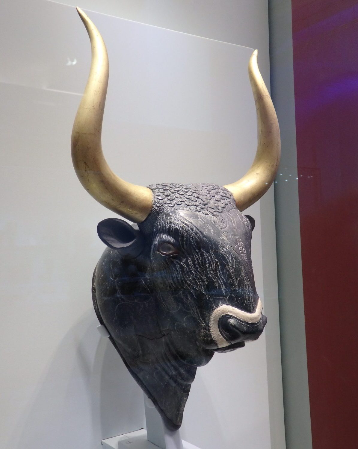 a bulls-head "rhyton" from Knossos, apparently used for libations. It can be filled through a hole in the neck and the liquid can be poured out through the snout. Carved from stone, with inlays of shell, rock crystal and red jasper.