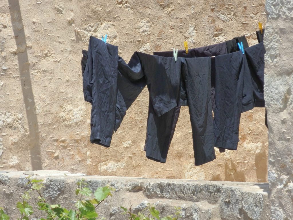 A clothesline with black trousers hanging from it.