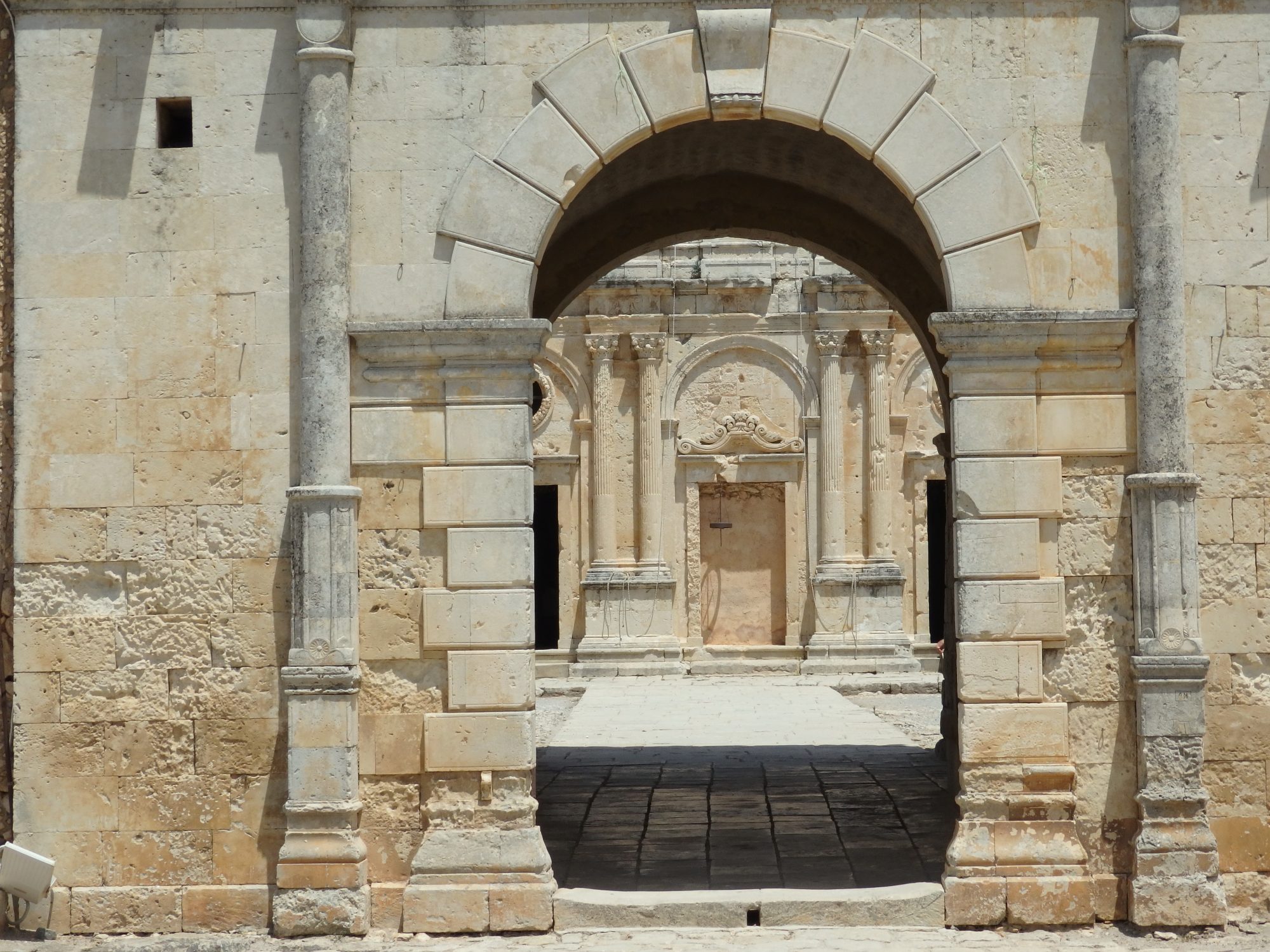 The west gate of Arkadi monastery, with the church in the background.