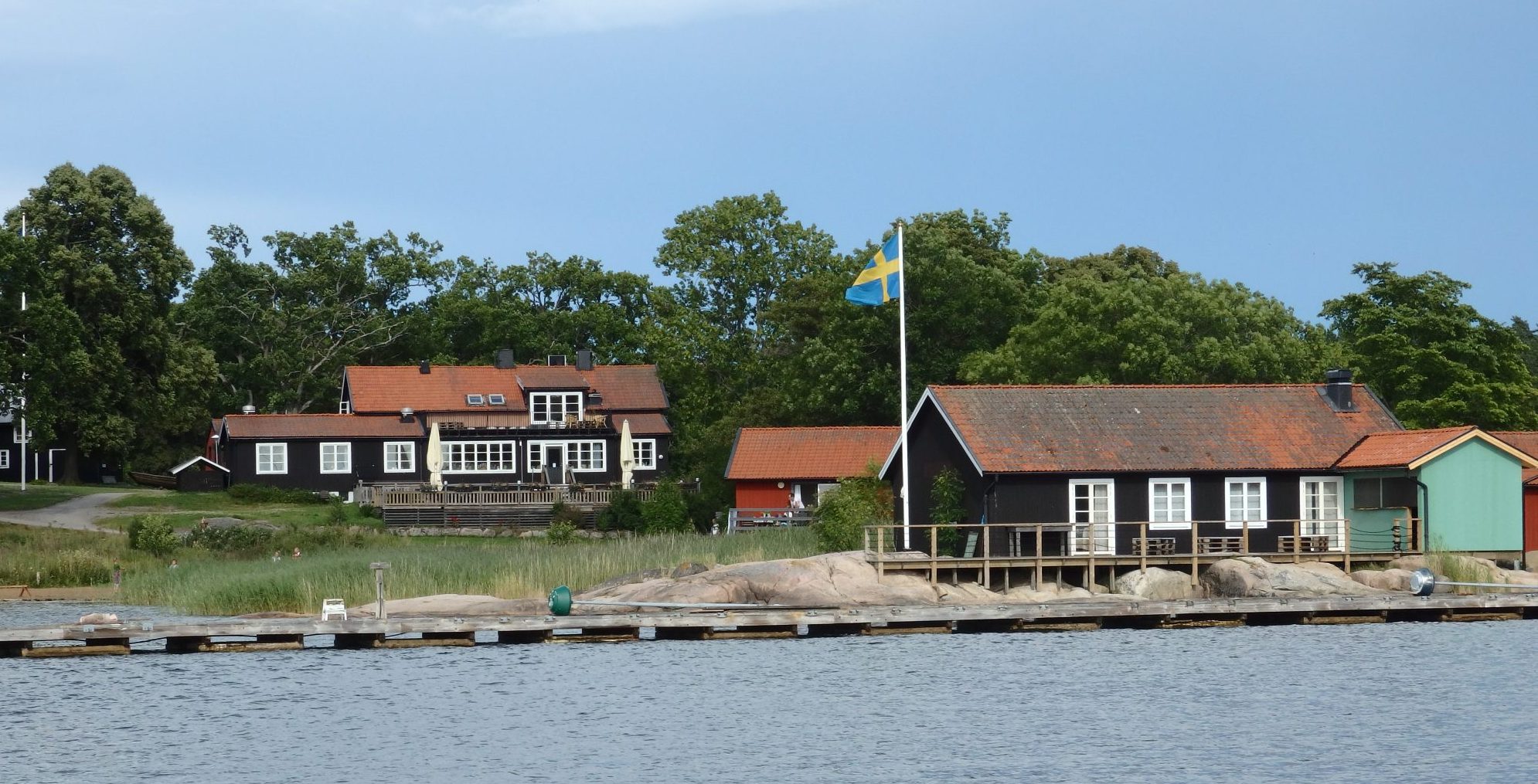 The building on the rise on the left is the restaurant and reception. The building with the flagpole in front will soon be a bar and cafe. Nasslingen, Sweden