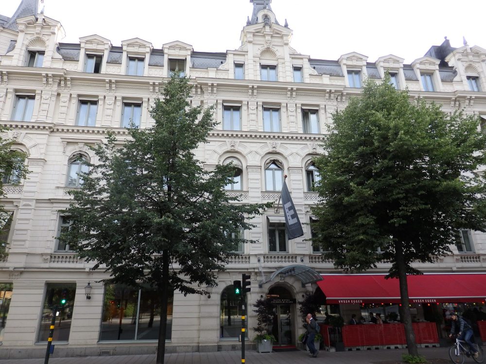 Elite Hotel Stockholm Plaza is a white building, 5 stories tall, with decorative elements between and framing the windows. 