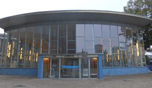 A rounded front of the building, with the entire front facade being panes of glass.