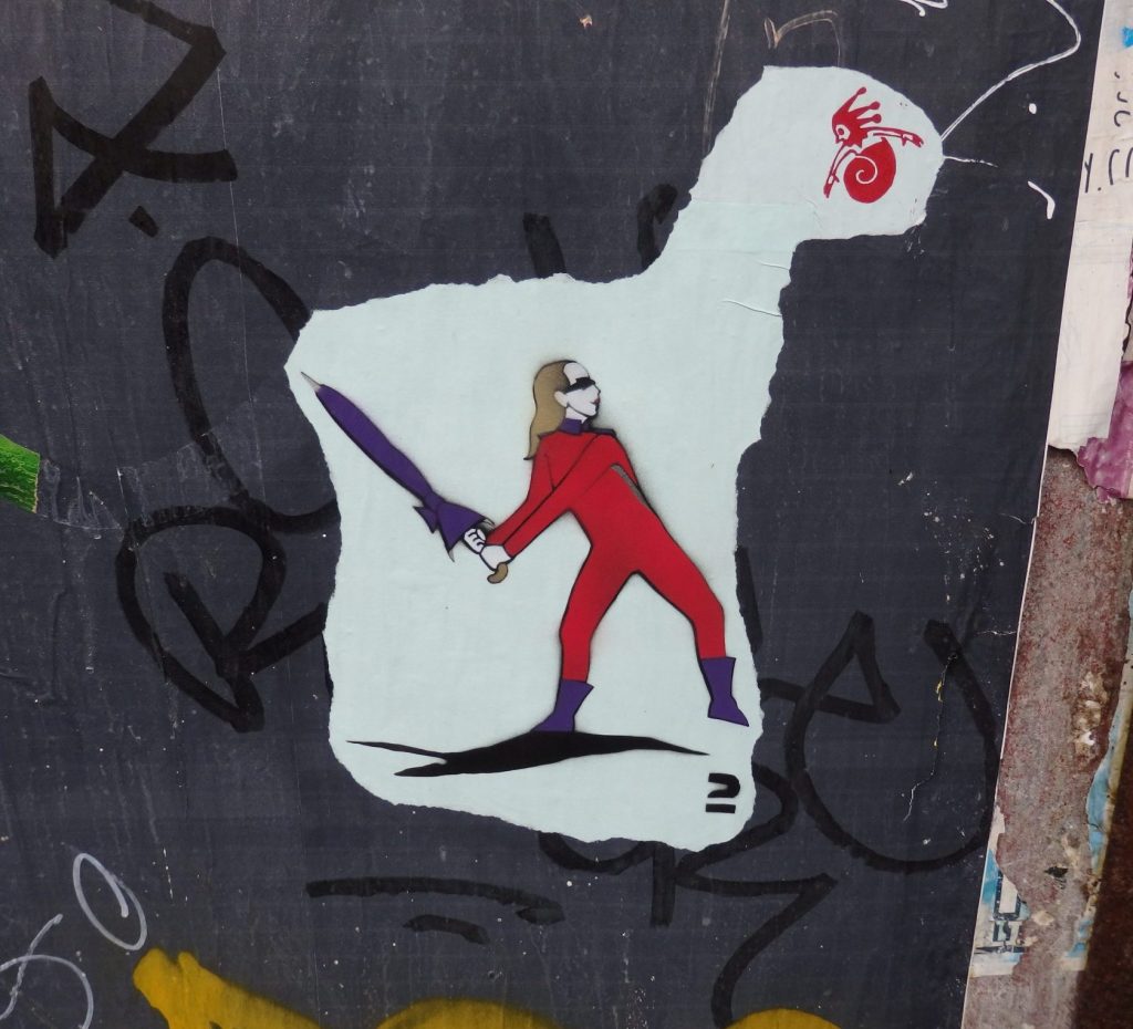 An image of a person dressed in a red outfit much like a superhero, swings a closed umbrella at what looks like a fairy.