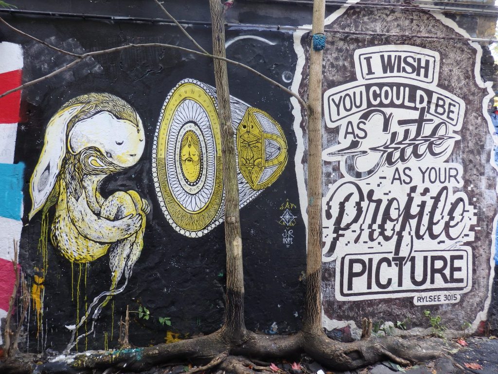 Left, some sort of furry creature with long ears hanging behind, floating next to a cone shaped thing and, on the right, a sign reading "I wish you could be as cute as your profile picture."