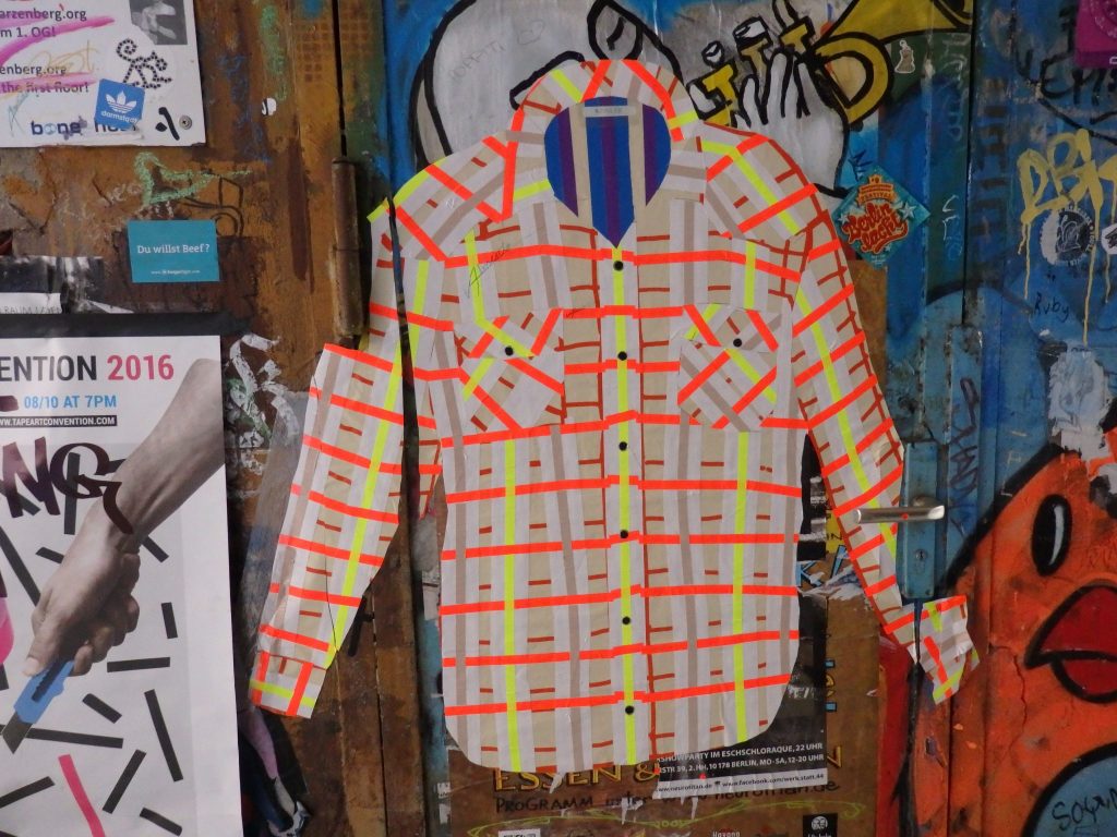 An image of a shirt, with collar and pockets in bright orange and yellow tape stripes.