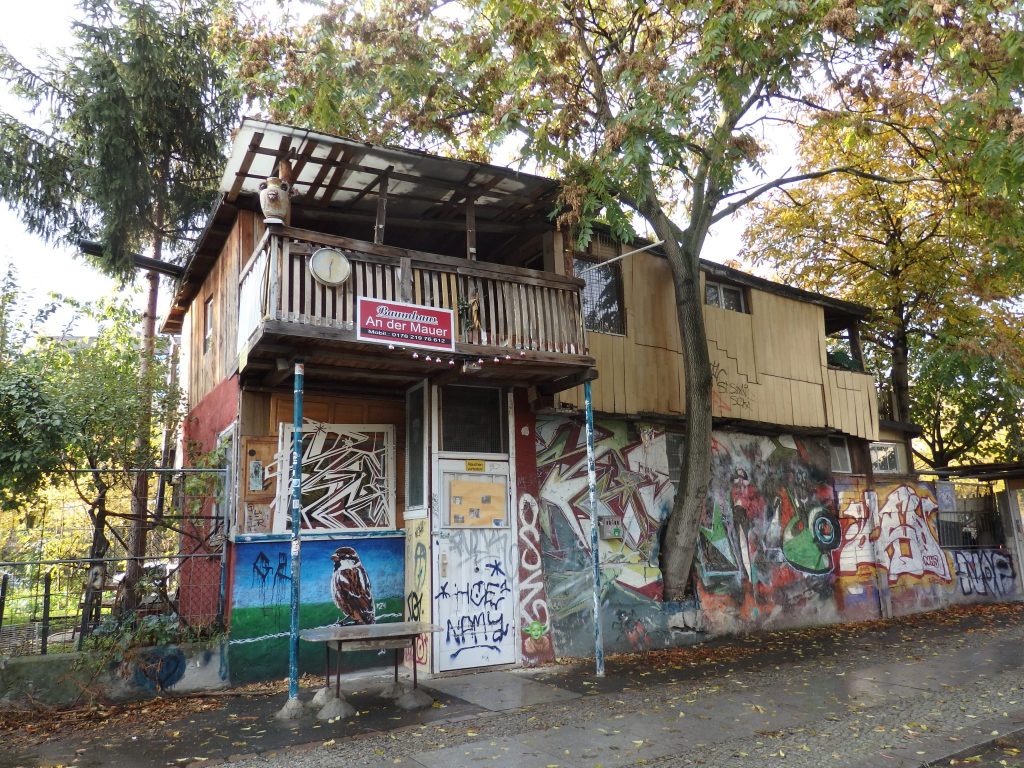 The building is two stories and the ground floor has lots of graffiti on it. There's a small balcony on the upper floor.