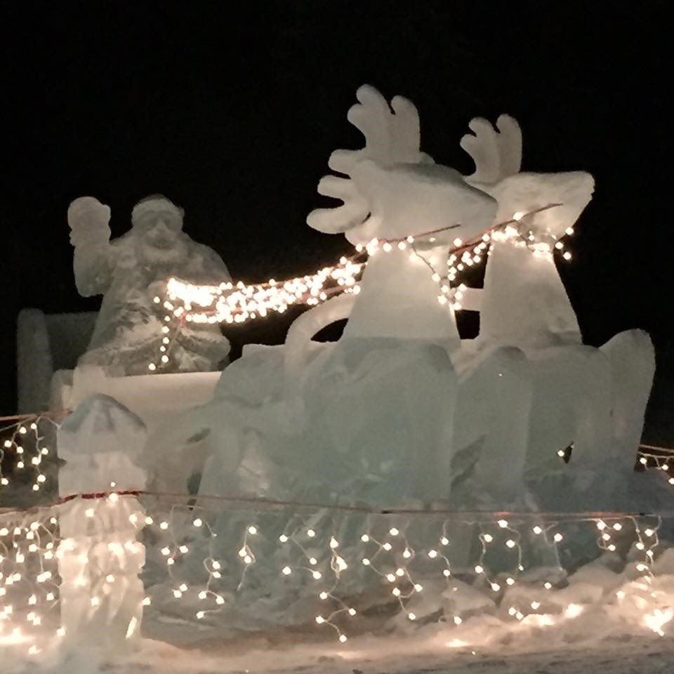 A santa and two reindeer pulling his sleigh, all carved out of ice. The reins are white Xmas lights.  Photo courtesy of Carol Esguerra Colborn