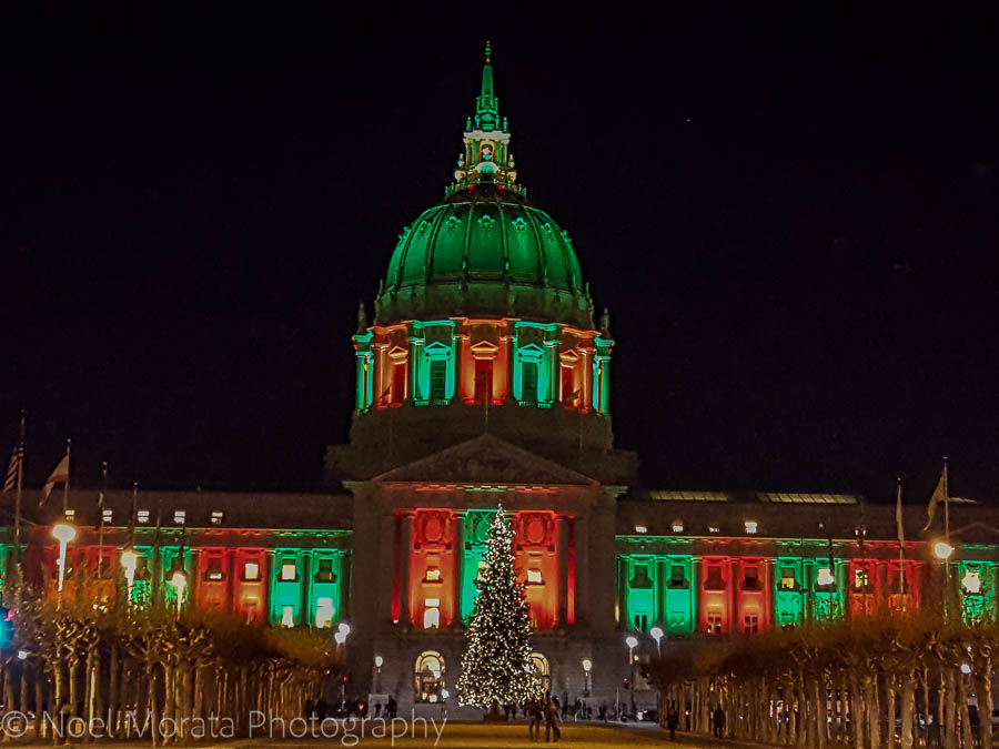 San Francisco City Hall (big classical domed building) lit up in green and red against a black sky.  