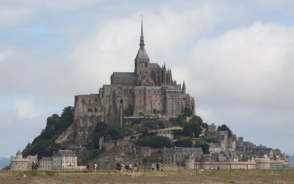 A hill emerges from a plain. It is topped with a large building and seemingly right on top of that, a church, with a tall steeple. 25 real tips for women traveling alone.