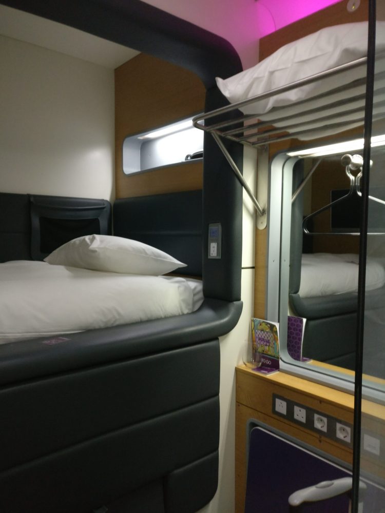 In this photo from the Yotel you can see how high the bed is. The pull-out desk is under the row of electrical outlets. You can also see the pink light up top.