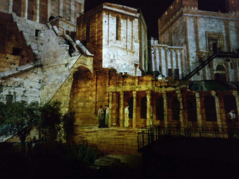 The images are dynamic and 20 different projectors are used. In this scene, which seems to alter the shape of the buildings it's projected onto, the people at the base of the image were walking together.