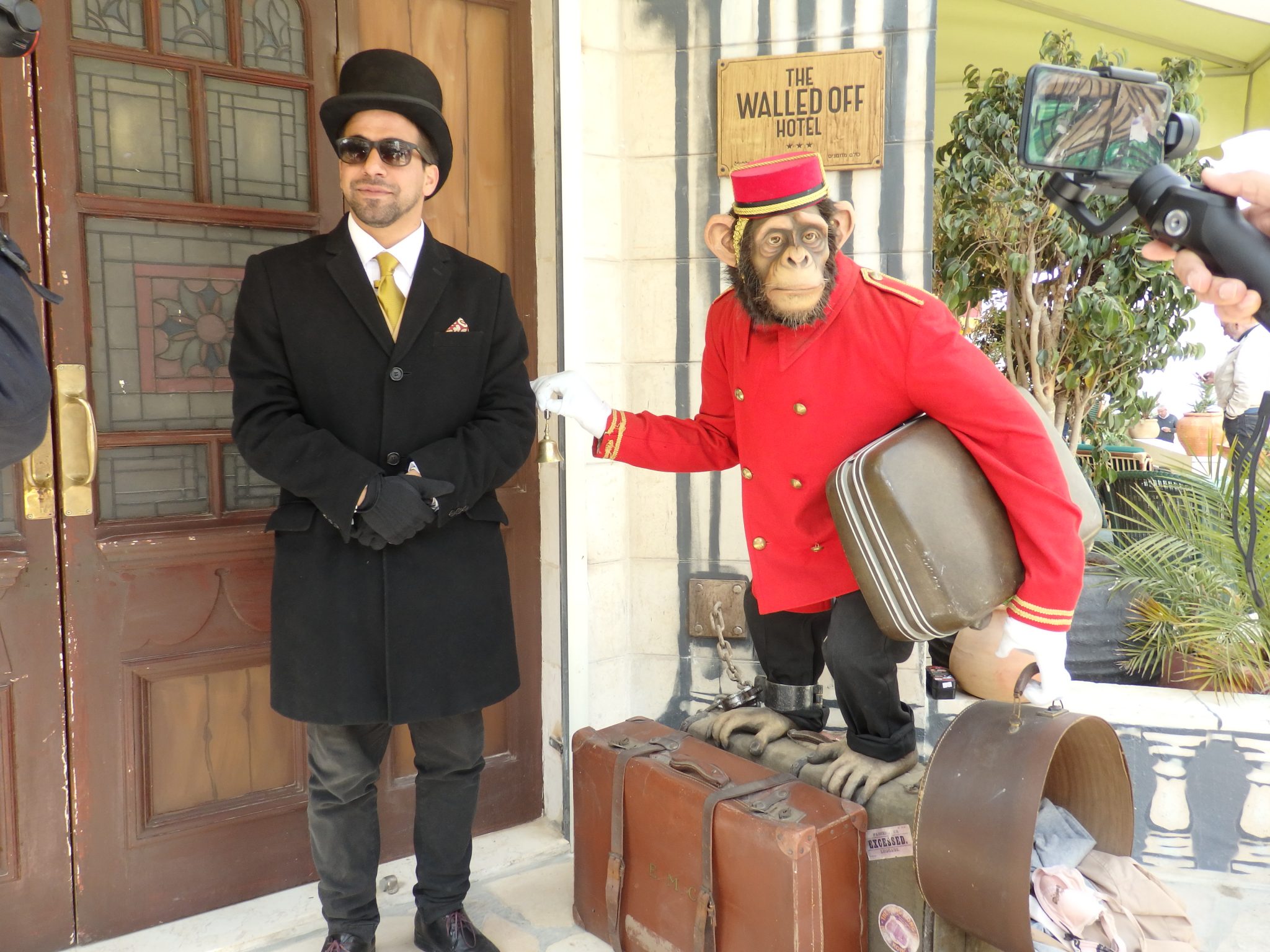 At the entrance to the Walled Off Hotel, the doorman and the "bellboy." Visiting Bethlehem