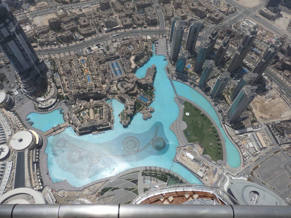 A big blue pond is in the center of the photo, surrounded but both low and high-rise buildings, all in grey.