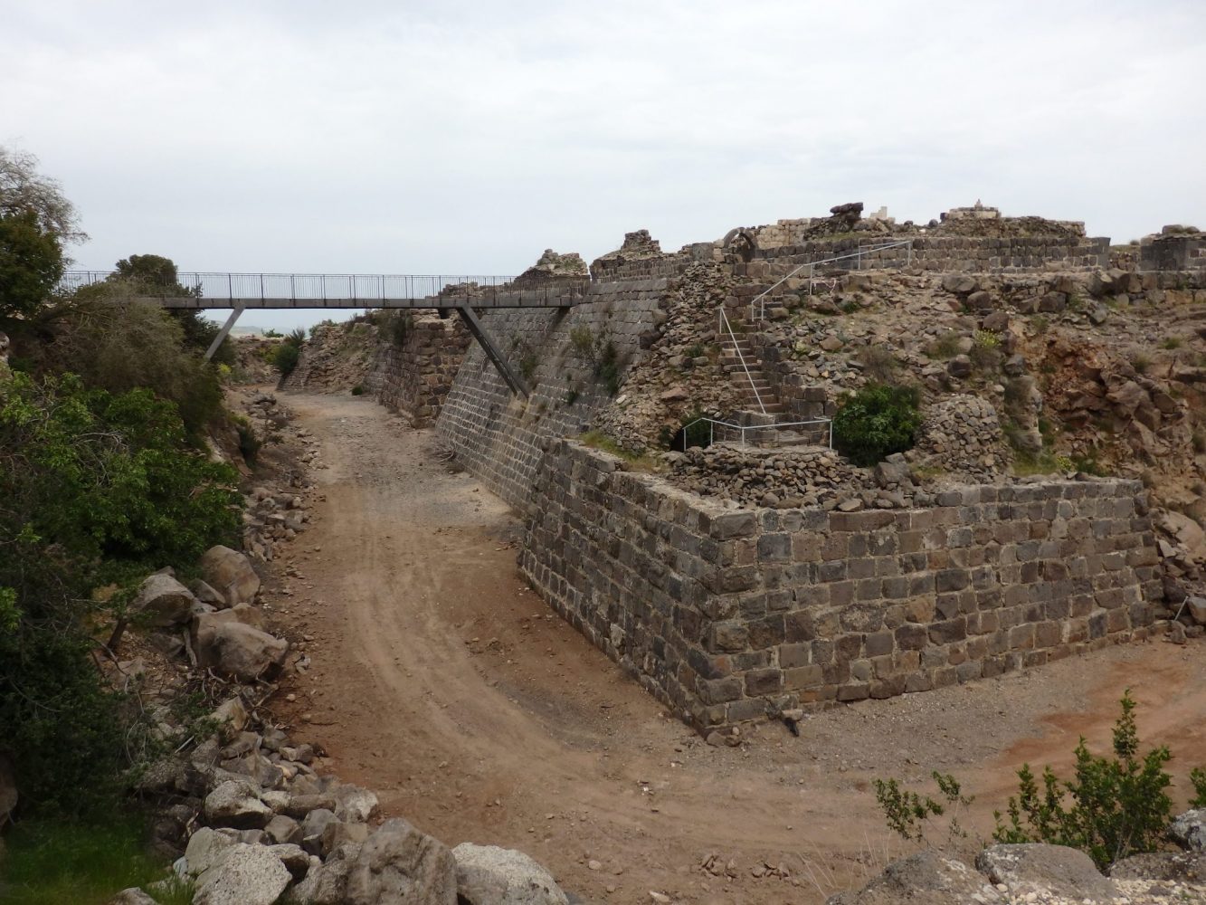 This photo shows one corner of Belvoir Fortress and the moat around it. The modern walking bridge is in the spot where the original drawbridge would have been, and gives you an idea of how deep the moat is and how high the walls still are.