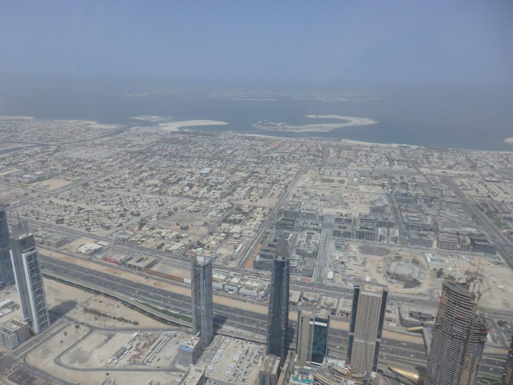 Here you can see a lower-rise area of Dubai, mostly housing. In the dim distance is the coast, and beyond it are the artificial islands called the "World Islands". Visiting Burj Khalifa