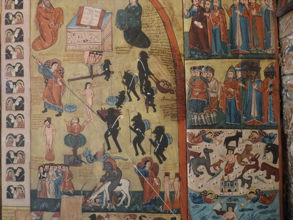 The fresco has images of naked people suffering in various ways (fire, in several cases) and being tormented by black devils with long tongues and some sort of grey round thing on their backs.