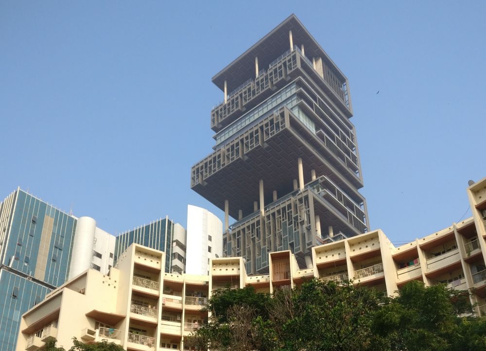 Skyscraper looming over a smaller apartment building.