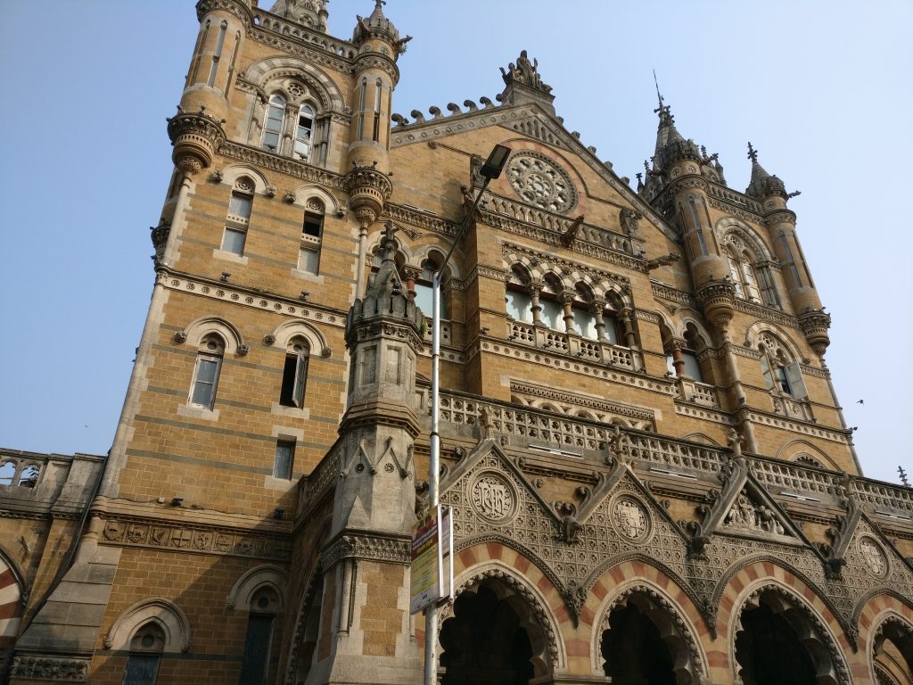A neo-Gothic style exterior of brick with arched windows and decorations along all the edges.