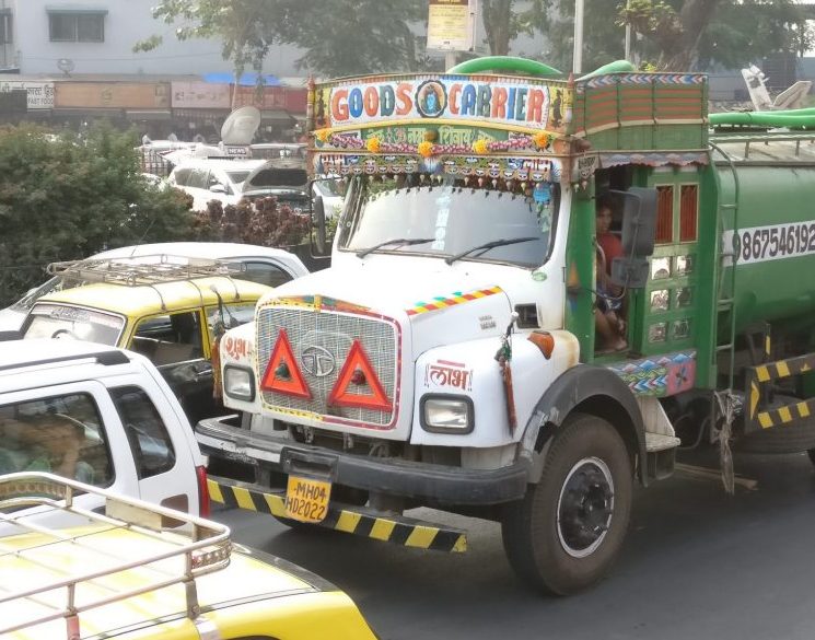 a colorful truck in the traffic of Mumbai