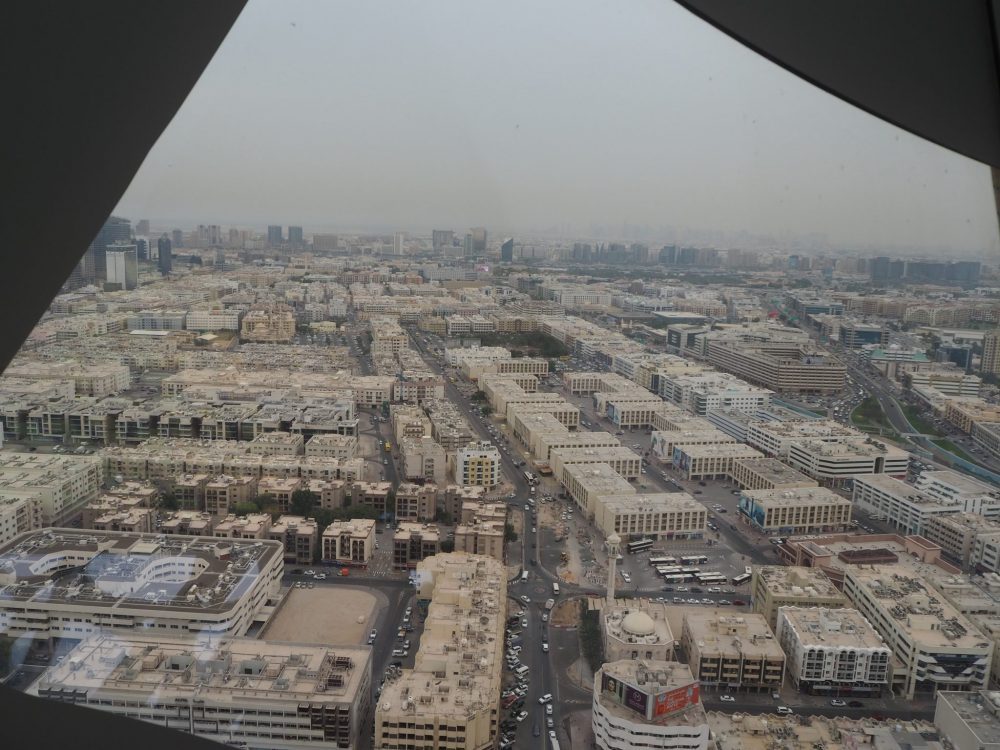 This is a predominantly light brown view, with neat blocks of low-rise apartments and straight streets dividing them. While the buildings are light brown, the sky is grey and the view gets pretty fuzzy in the distance from the pollution/dust in the air.