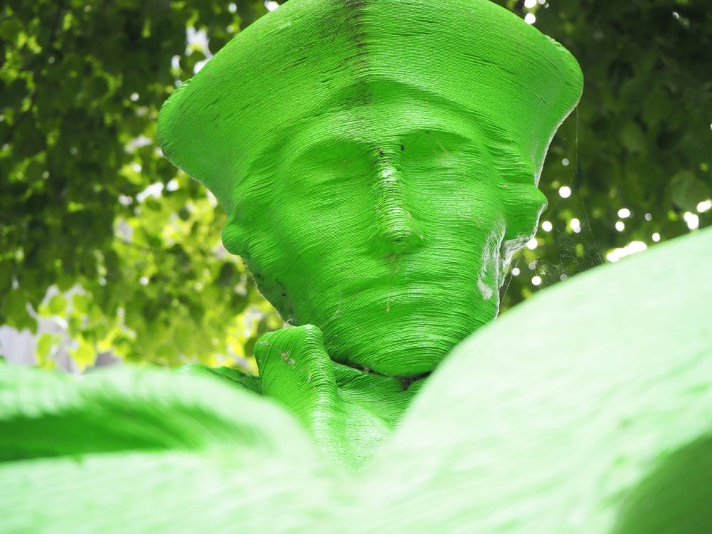 In this bright green close-up of Erasmus's face, the layers of the plastic 3D print are clearly visible.