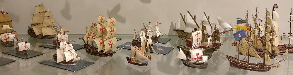 Tiny scale models of historical ships, complete with detailed sails and rigging.