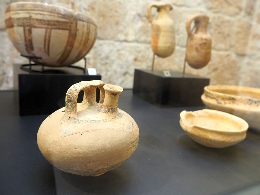 A number of clay containers in a display case.