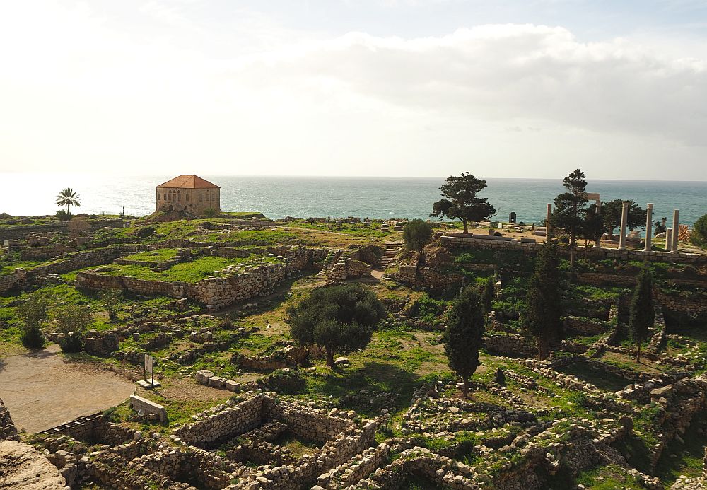 low stone walls, roman columns and the sea beyond.