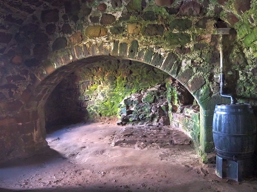 an archway shows what remains of a hearth and a dirt floor in the Dunnottar Castle kitchen.